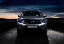 A silver Nissan Pathfinder is parked on a road under a darkening evening sky, 2K Desktop Wallpaper