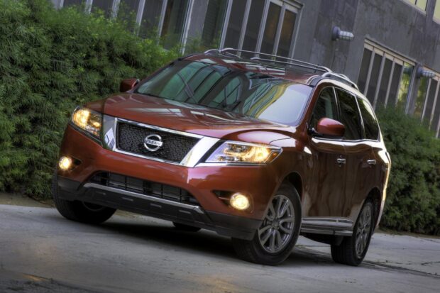A Nissan Pathfinder with headlights on parked near greenery and buildings, HD Desktop Wallpaper