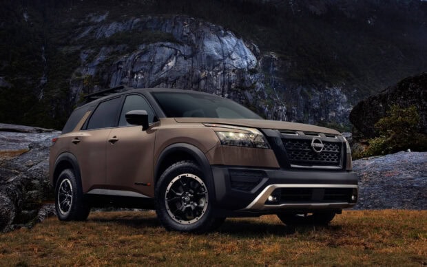 A Nissan Pathfinder is parked in a rugged mountain area with rocky cliffs in the background, HD Desktop Wallpaper