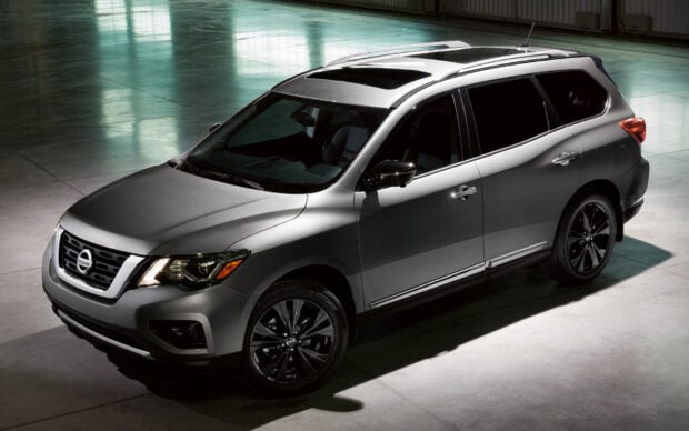 A silver Nissan Pathfinder is parked inside a spacious showroom with a shiny floor, HD Desktop Wallpaper