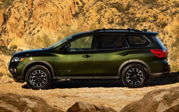 A Nissan Pathfinder parked in front of rocky desert hills under sunlight, HD Desktop Wallpaper