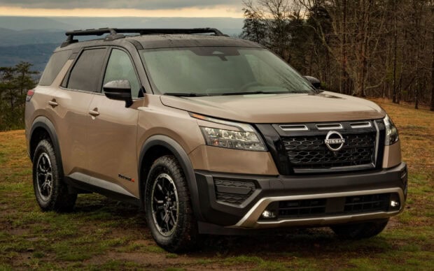 A beige Nissan Pathfinder parked near a forest on a cloudy day, HD Desktop Wallpaper