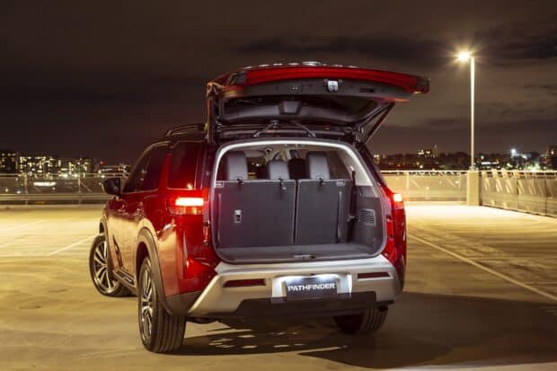 A red Nissan Pathfinder with its rear hatch open in a nighttime parking lot, HD Desktop Wallpaper