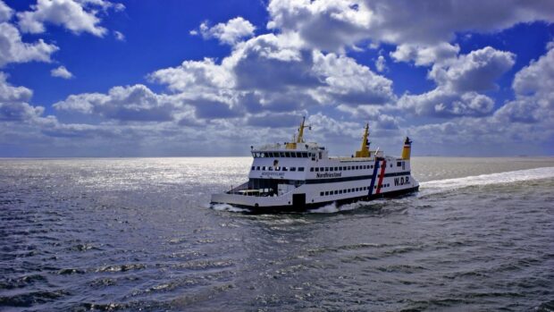 A ferry sails through calm waters under a partly cloudy sky with reflections on the sea, HD Desktop Wallpaper