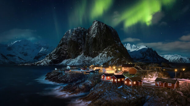The northern lights illuminate a small fishing village beside rocky mountains in Norway, 4K Desktop Wallpaper