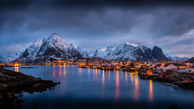A peaceful Norway village by the water with snow covered mountains in the background, 4K Desktop Wallpaper