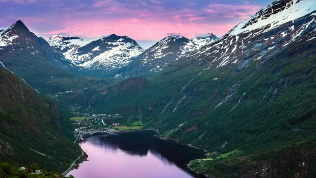 A peaceful fjord surrounded by snowy mountains under a purple sunset sky in Norway, 4K Desktop Wallpaper