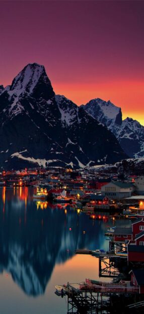 A colorful sunset reflects over a peaceful Norwegian village with snowy mountains, HD Mobile Wallpaper