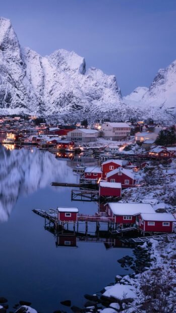 A peaceful Norway town with snowy mountains and calm water reflecting the scenery, 2K Mobile Wallpaper