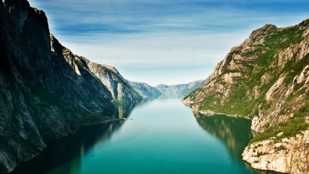 The Norwegian fjords offer a stunning view with calm waters and steep rocky cliffs, HD Desktop Wallpaper