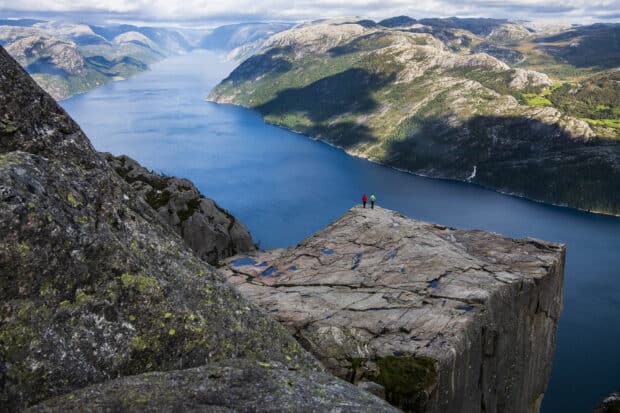 Two hikers stand on a cliff overlooking the Norwegian fjords and mountains, HD Desktop Wallpaper