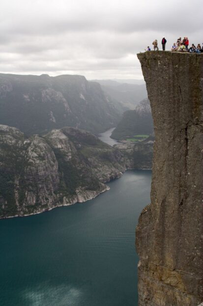 People standing on a cliff overlooking Norwegian fjords and deep blue water, HD Mobile Wallpaper
