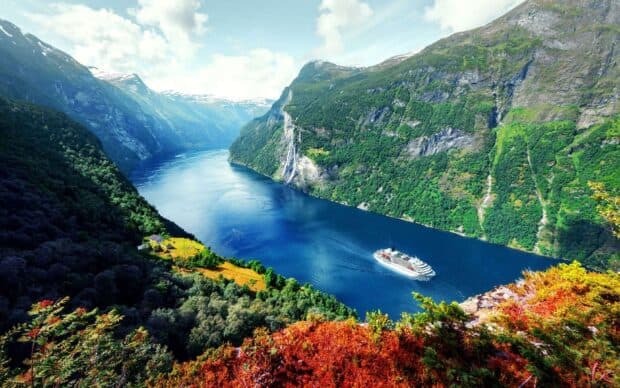 A cruise ship sails through the deep blue waters of the Norwegian fjords surrounded by mountains, HD Desktop Wallpaper