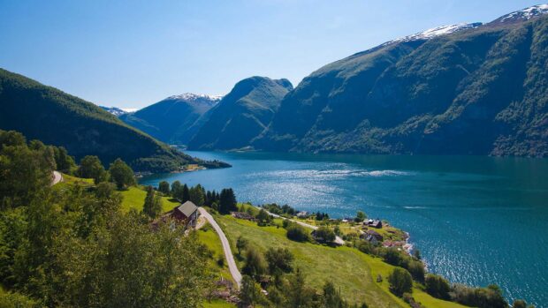 A scenic view of Norwegian fjords with green hills and sparkling water under a clear sky, HD Desktop Wallpaper