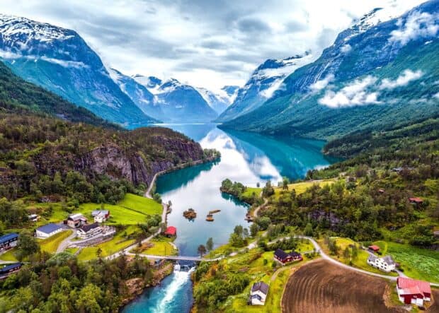 A breathtaking view of Norwegian fjords surrounded by green hills and towering mountains, 2K Desktop Wallpaper