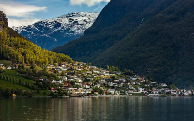 A peaceful village lies by the Norwegian fjords with snowcapped mountains in the background, HD Desktop Wallpaper