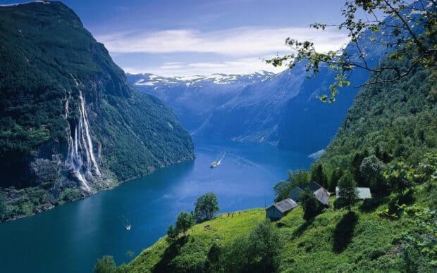 A scenic view of Norwegian fjords with waterfalls, mountains, and boats on the water, HD Desktop Wallpaper
