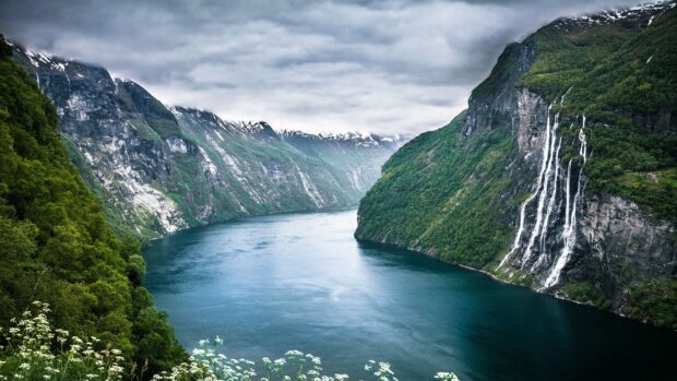 A scenic view of Norwegian fjords with cascading waterfalls and snow capped mountains, 4K Desktop Wallpaper