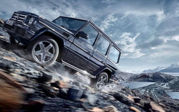 A rugged vehicle navigates off road driving through a rocky and mountainous landscape, 2K Desktop Wallpaper