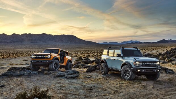 Two off road vehicles parked on desert rocks during sunset, HD Desktop Wallpaper