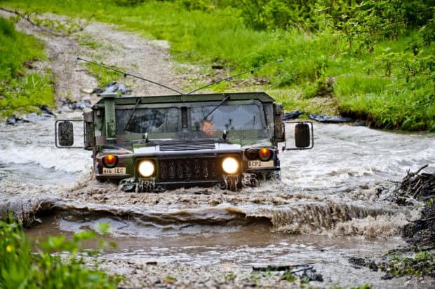 A military vehicle is driving through muddy water on an off road trail, HD Desktop Wallpaper