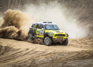 A rally raid vehicle kicks up dust as it speeds through a sandy terrain, 2K Desktop Wallpaper