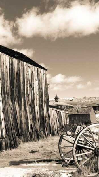 This ghost town features old wooden buildings and an abandoned wagon under a cloudy sky, HD Phone Wallpaper