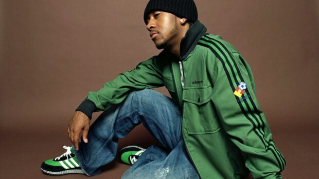 Omarion is sitting wearing a green jacket and jeans with a black beanie, HD Desktop Wallpaper