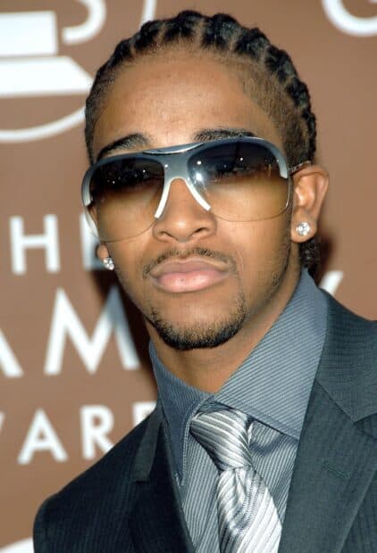 Omarion wearing sunglasses and a suit with a patterned tie in a close up portrait, 2K Mobile Wallpaper