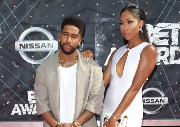 Omarion with a woman posing at an event wearing stylish outfits with the Nissan logo behind, HD Desktop Wallpaper