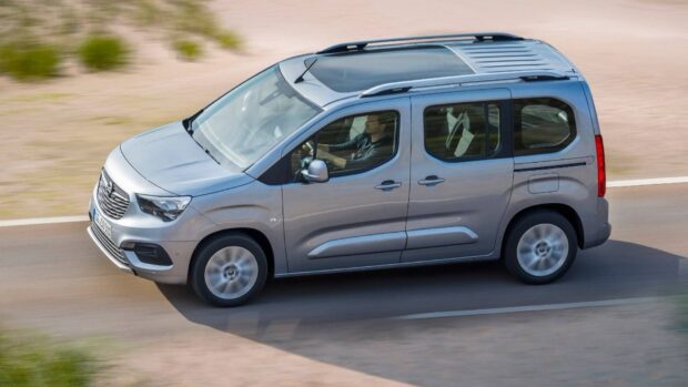 A silver Opel Combo driving along a paved road with a visible driver inside, HD Desktop Wallpaper