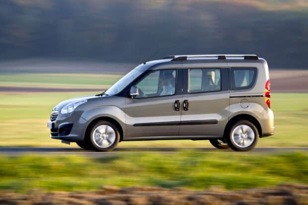 An Opel Combo driving fast through the countryside with a blurred background, 2K Desktop Wallpaper
