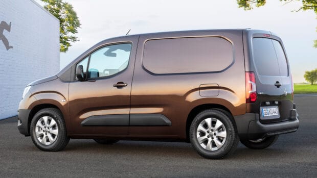 A brown Opel Combo is parked on pavement beside a white brick wall and greenery, 4K Desktop Wallpaper