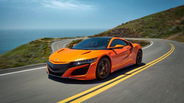 Orange Honda NSX driving along a curvy road by the ocean under clear blue sky, HD Desktop Wallpaper