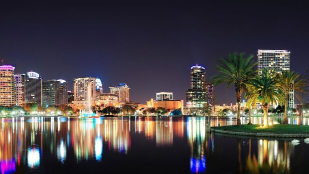 The Orlando skyline is beautifully lit reflecting on the calm water at night, HD Desktop Wallpaper