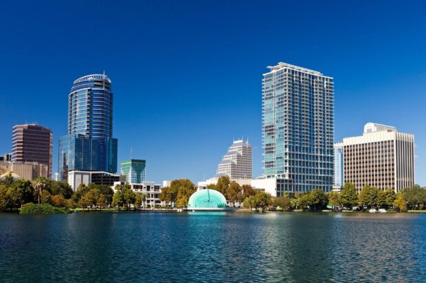 The Orlando skyline is reflected in the calm lake under a clear blue sky, HD Desktop Wallpaper