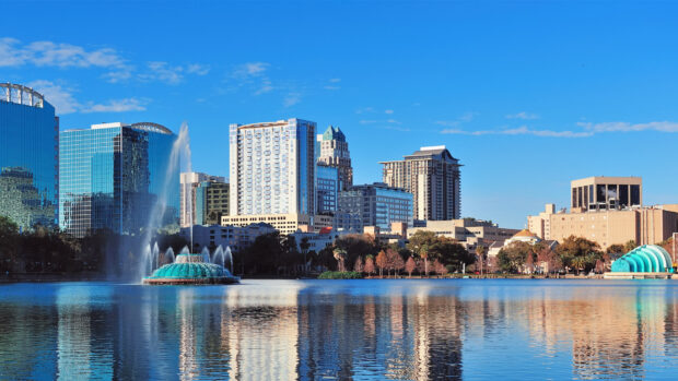 Orlando Wallpapers capture the city skyline with a lake and fountain reflecting under a clear blue sky, HD Desktop Wallpaper