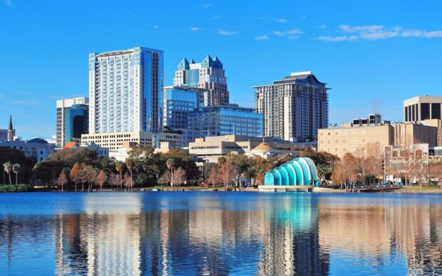 The Orlando skyline reflects beautifully on the calm lake under a clear blue sky, HD Desktop Wallpaper