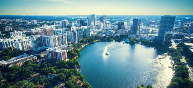 A scenic view of Orlando with its buildings and lake under a clear sky, HD Desktop Wallpaper
