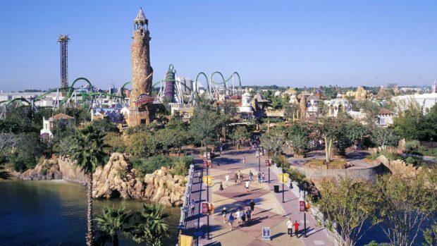 People walking near the theme park in Orlando with roller coasters and towers, HD Desktop Wallpaper