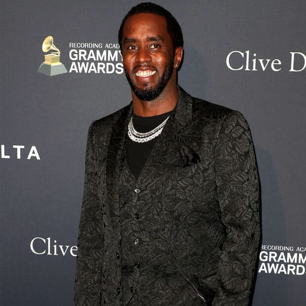 P Diddy Sean Combs smiles warmly while attending a music event in a patterned black suit, HD Desktop Wallpaper