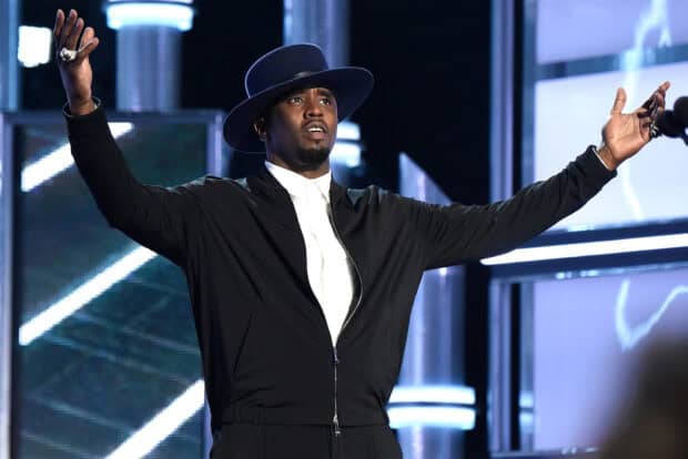 P Diddy Sean Combs raises his arms wearing a black jacket and hat on stage, HD Desktop Wallpaper