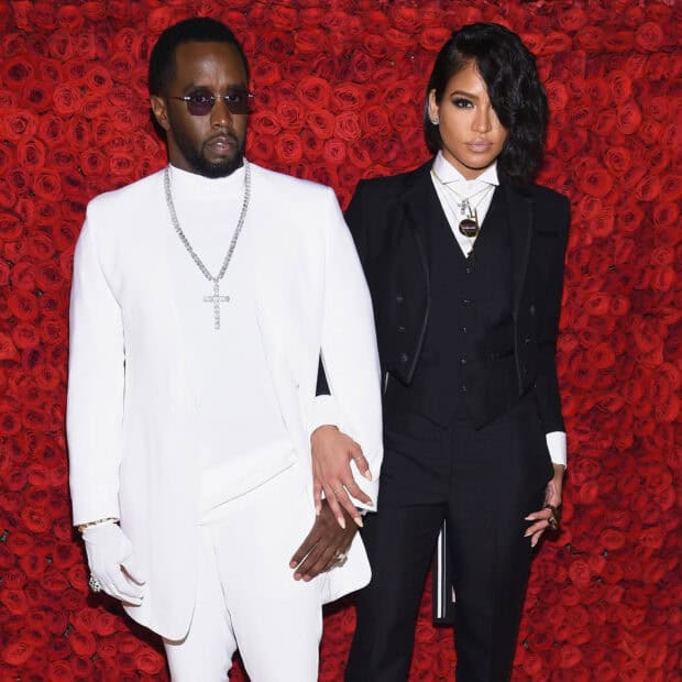 P Diddy Sean Combs is posing in a white suit standing next to a woman in a black suit against a red rose background, HD Desktop Wallpaper
