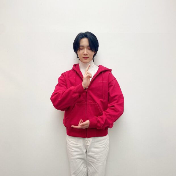 A P1Harmony member poses with closed eyes wearing a red hoodie and white pants, HD Mobile Wallpaper