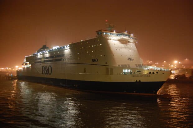 The ferry illuminated by lights sails through calm water in the evening, 2K Desktop Wallpaper
