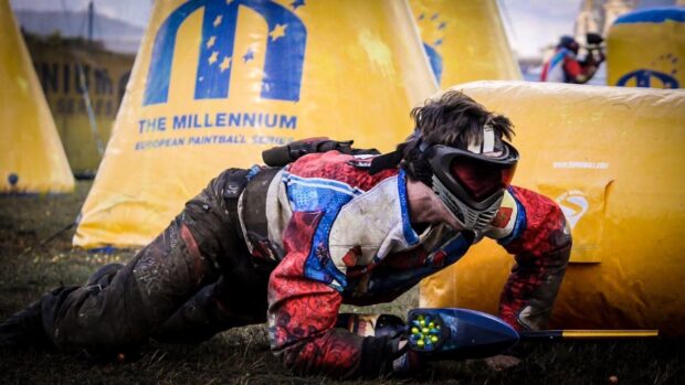 A paintball player is crawling behind inflatable barriers in an intense paintball game, HD Desktop Wallpaper