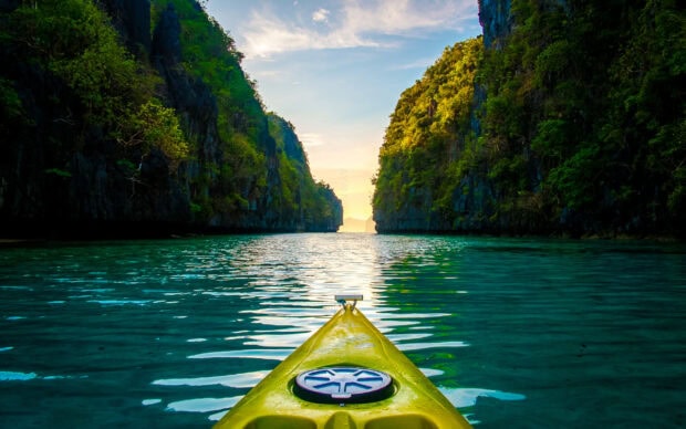 A kayak is floating between limestone cliffs over clear water in Palawan, 2K Desktop Wallpaper