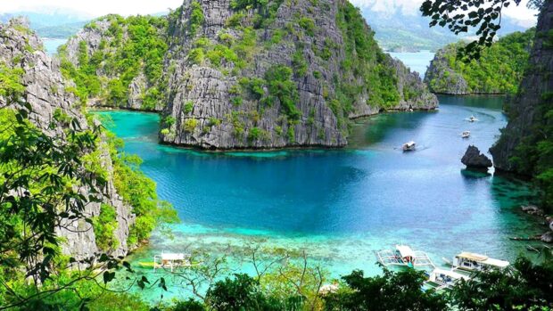 The Palawan landscape features clear blue water and limestone cliffs with boats, HD Desktop Wallpaper
