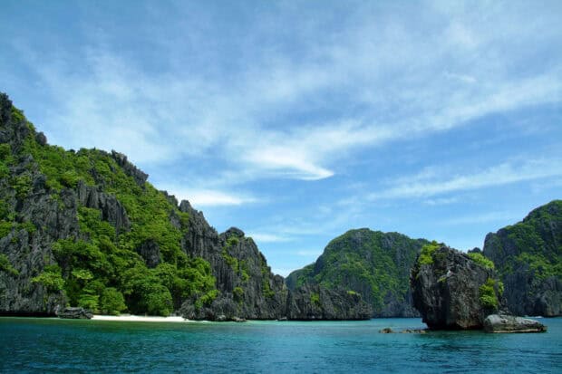 The Palawan limestone islands rise above clear blue water under a bright sky, HD Desktop Wallpaper