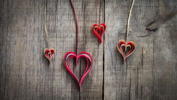 Handmade heart shape decorations are hanging on a wooden wall, 4K Desktop Wallpaper